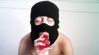 Masked teen giving a blowjob to a dildo