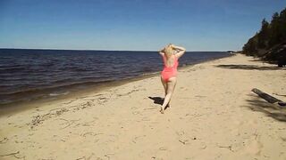 Juicy MILF in a pink swimsuit, on the beach