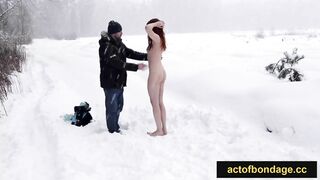 Readhead girl totally undressed and tied up in the snow. Barefoot naked bondage