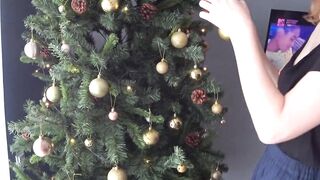 BABY SQUIRTING MILK NEAR THE CHRISTMAS TREE