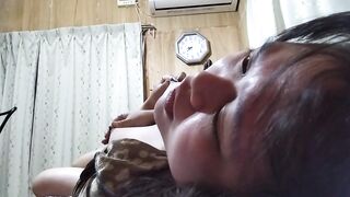 A busty Japanese woman makes an expression of agony while pulling her nipples.